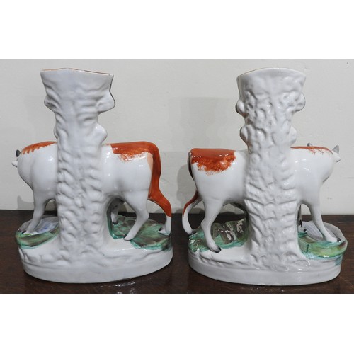 420 - A PAIR OF 19TH CENTURY COW AND CALF STAFFORDSHIRE SPILL VASES and a 19th century spill vase in the f... 