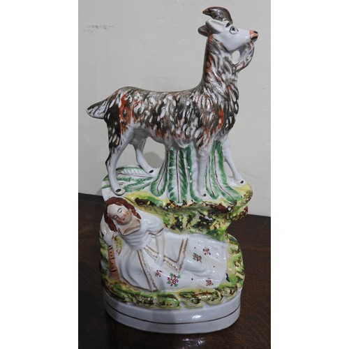 556 - A PAIR OF 19TH CENTURY STAFFORDSHIRE FIGURES DEPICTING A SLEEPING COUPLE UNDER GOATS, 28 cm high