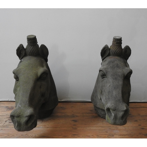 116 - A PAIR OF RECONSTITUTED STONE ORNAMENTAL HORSE'S HEAD, of weathered appearance, 56 cm high x 70 cm l... 