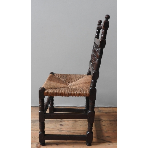 54 - AN 18TH CENTURY OAK RUSH SEAT CHAIR, with a turned top rail, turned spindle back,. on four turned le... 