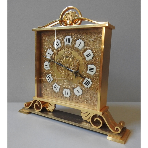 167 - A SWISS IMHOF ORNATE BRASS MANTEL CLOCK, repousse decorated square dial with enamel Roman numerals, ... 