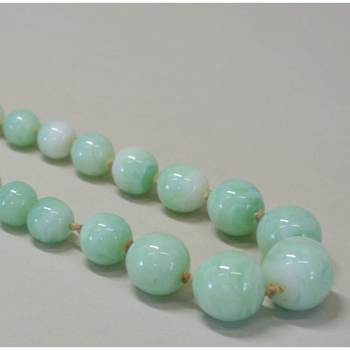 466 - A GLASS IMITATION JADE BEAD NECKLACEGraduating green glass beads with silver bolt fastening.Weight 5... 