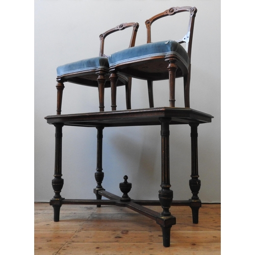 83 - A VICTORIAN WALNUT EBONISED SIDE TABLE, the canted corner top raised on four fluted legs united by a... 