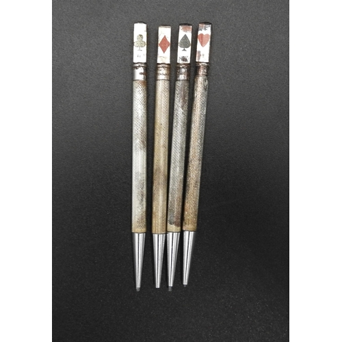 451 - A SET OF FOUR SILVER PROPELLING PENCILS, each with machine turned barrels and decorated with hearts,... 