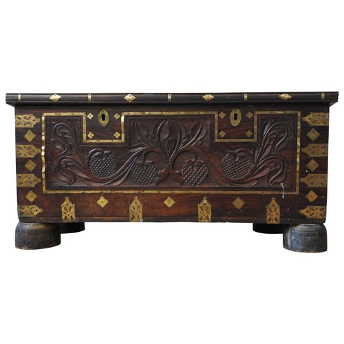 106 - A CARVED HARDWOOD EASTERN STORAGE TRUNK, with decorative brass mounts and banding throughout, the fr... 