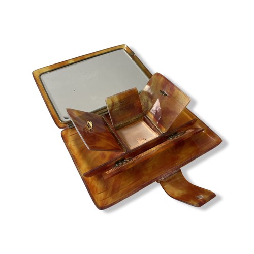 508 - A BAKELITE VANITY CASEIn tortoise shell style, with comb, three hinged opening compartments and mirr... 