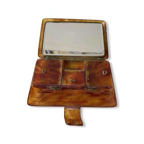 508 - A BAKELITE VANITY CASEIn tortoise shell style, with comb, three hinged opening compartments and mirr... 