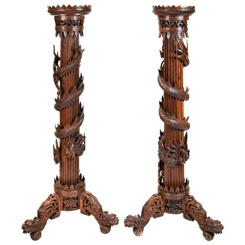 399 - IMPRESSIVE PAIR OF DRAGON-CARVED HUANGHUALI STANDSQING DYNASTY, 19TH CENTURYthe circular castellated... 