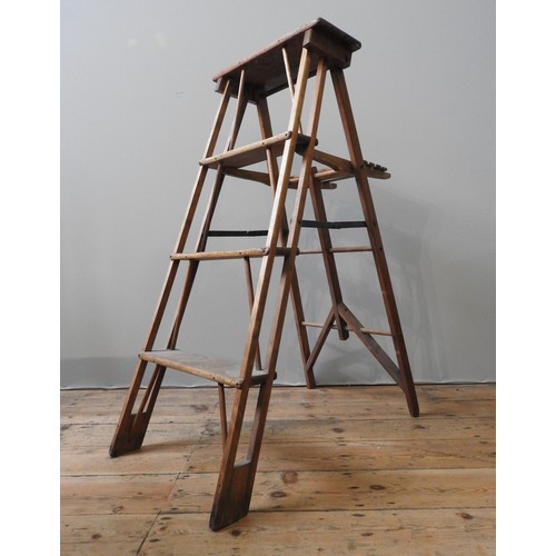 96 - A VINTAGE PINE FOLDING STEP LADDER, the four tread ladder with a fold down table top, 114 x 45 cm