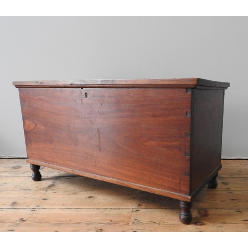22 - A MAHOGANY BLANKET BOX, of simplistic form, constructed from dovetailed panels, on four turned legs,... 