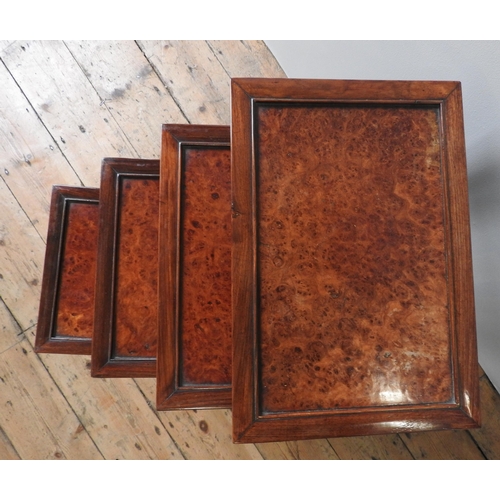 29 - A NEST OF FOUR CHINESE STYLE SIDE TABLES, burr walnut top panels inset in a hardwood frame, the pier... 