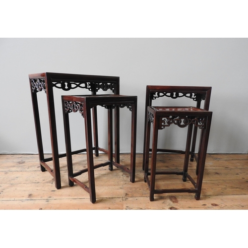 29 - A NEST OF FOUR CHINESE STYLE SIDE TABLES, burr walnut top panels inset in a hardwood frame, the pier... 
