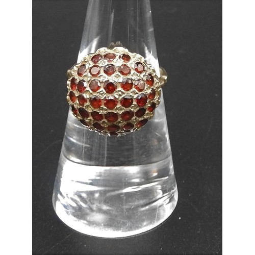 384 - A 9CT GARNET RINGLate 20th century, Domed design pave set with garnets on a tapered shank which join... 