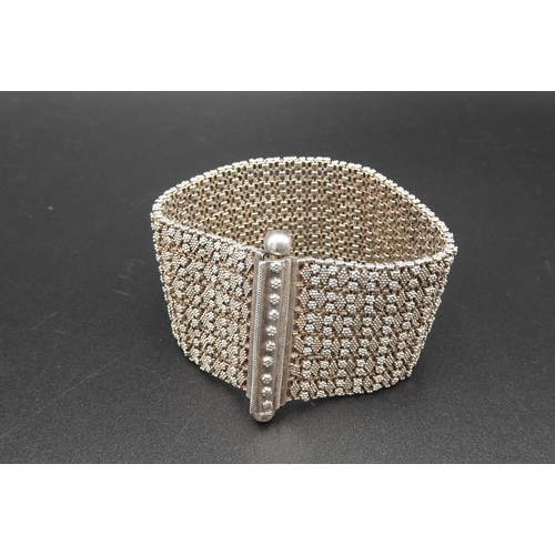 379 - A HEAVY SILVER BRACELETwith fine granulation decoration on a flexible woven chain bracelet.UnmarkedW... 