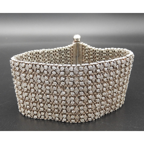 379 - A HEAVY SILVER BRACELETwith fine granulation decoration on a flexible woven chain bracelet.UnmarkedW... 