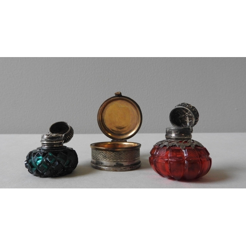 341 - TWO VICTORIAN SILVER MOUNTED SCENT BOTTLES AND A WHITE METAL PILL BOX, the ruby and emerald glass sc... 