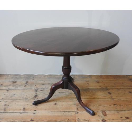 72 - A GEORGE III MAHOGANY TILT-TOP TRIPOD TABLE, the single piece top raised on a turned baluster pedest... 