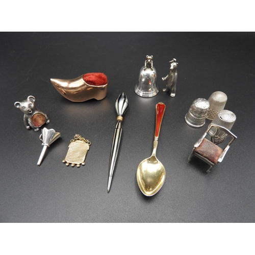 334 - THREE SILVER THIMBLES, THREE NOVELTY PIN CUSHIONS AND A SILVER TOOTH FLASK, along with charms, trink... 