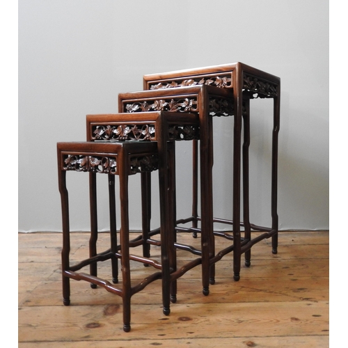 76 - A NEST OF FOUR CHINESE HARDWOOD TABLES, with ornate carved frieze panels, max height 71 x 42 x 34 cm