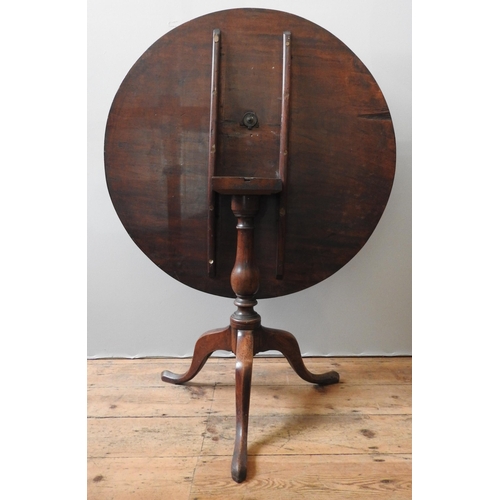 77 - A GEORGE III MAHOGANY TILT TOP TRIPOD TABLE, the circular single piece top sat atop a turned baluste... 