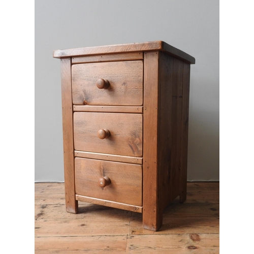 83 - A 20TH CENTURY PINE BEDSIDE CHEST, of simplistic form, consisting of three drawers with turned woode... 