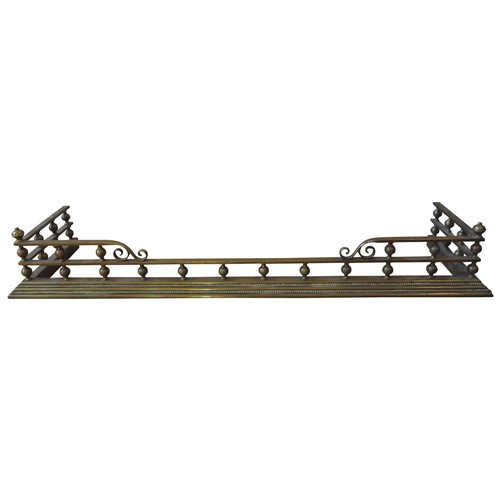 102 - A 19TH CENTURY BRASS FENDER, the twin rails united by turned finials, with a gadrooned edge base, 13... 