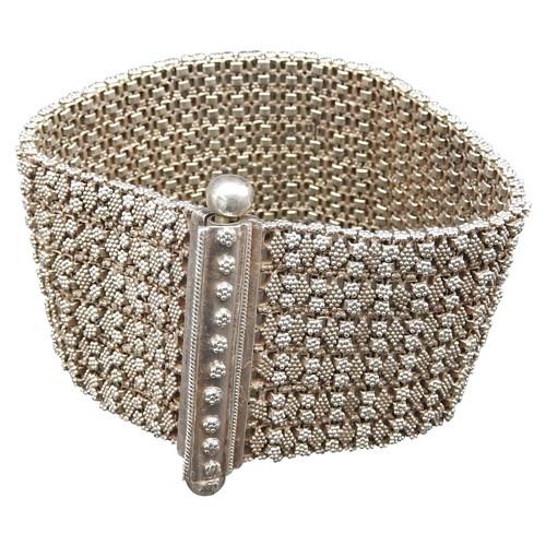 379 - A HEAVY SILVER BRACELETwith fine granulation decoration on a flexible woven chain bracelet.UnmarkedW... 