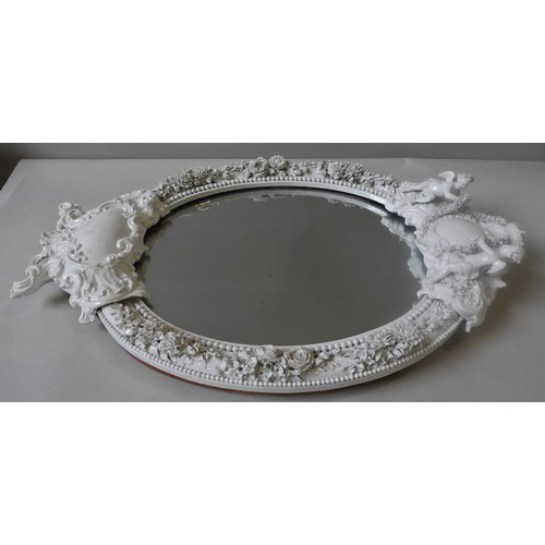 399 - A 19TH CENTURY MEISSEN BLANC DE CHINE OVAL WALL MIRROR, the porcelain frame with a central crown top... 