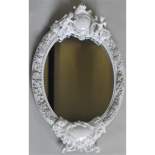 399 - A 19TH CENTURY MEISSEN BLANC DE CHINE OVAL WALL MIRROR, the porcelain frame with a central crown top... 