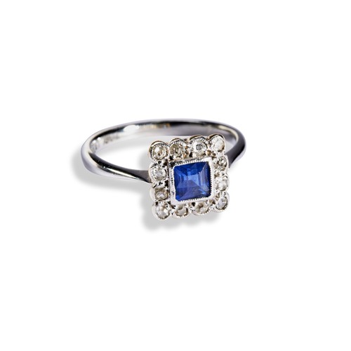 119 - A SAPPHIRE & DIAMOND PLAQUE RING CIRCA 1900.the millegrain square cut sapphire surrounded by twe... 