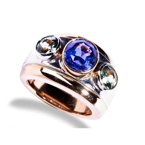 73 - THEO FENNELL SAPPHIRE RING an oval cut sapphire collet set in rose gold between two round cut green ... 