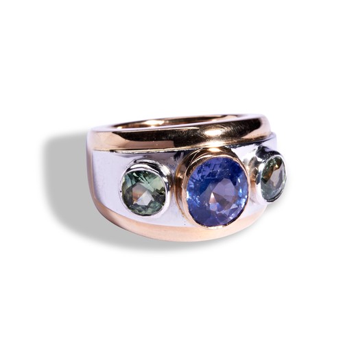 73 - THEO FENNELL SAPPHIRE RING an oval cut sapphire collet set in rose gold between two round cut green ... 