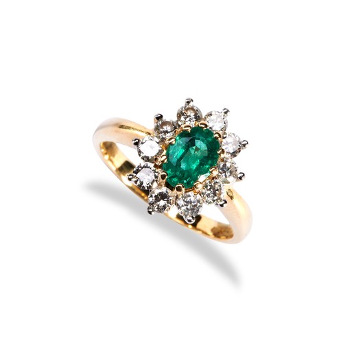 112 - AN EMERALD AND DIAMOND CLUSTER RING the central oval cut emerald set above ten round cut diamonds on... 