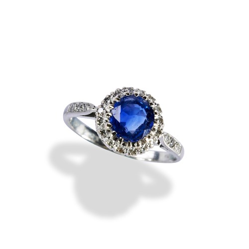 140 - A SAPPHIRE AND DIAMOND CLUSTER RINGthe circular mixed cut, within a bezel of sixteen eight-cut diamo... 