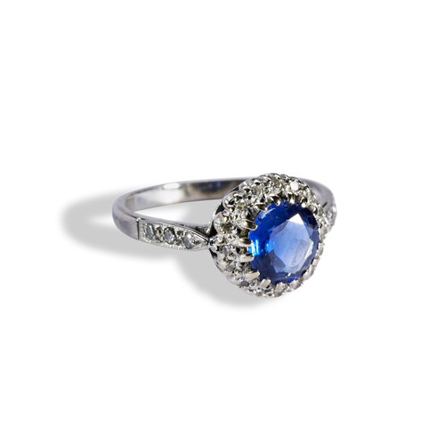 140 - A SAPPHIRE AND DIAMOND CLUSTER RINGthe circular mixed cut, within a bezel of sixteen eight-cut diamo... 