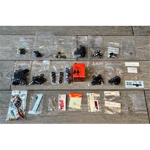 216 - A PACKAGE OF 1:43 SCALE SPARE PARTS  Containing a large selection of decals, tyres, and die-cast dri... 