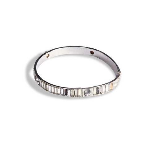208 - CHANEL; A CRYSTAL BANGLEA white metal bangle set with baguette cut and round cut paste. Many stones ... 