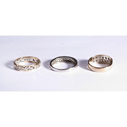 224 - THREE WHITE STONE DRESS RINGSAn eternity set gold and white metal dress ring, millegrain set with to... 