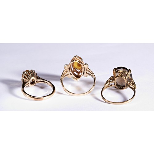 230 - THREE GOLD DRESS RINGSA marquise cut, yellow paste dress ring, with pireced decorative shoulders.Mar... 