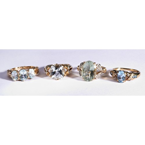 232 - FOUR GEM SET DRESS RINGSAN oval mixed cut, claw set, topaz with open dropped shaped shoulders set wi... 