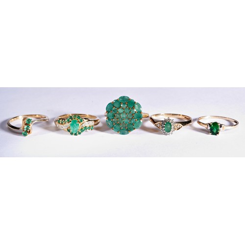 235 - FIVE GREEN STONE DRESS RINGSA claw set emerald cluster ring, set with round and oval cut emeralds.Ma... 