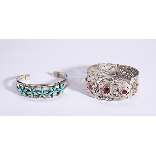 300 - A COLLECTION OF CUFF BRACELETSIncluding a silver cuff set central flower design, set with red a blue... 