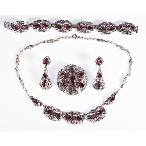 302 - A SET OF COSTUME JEWELLERY silver plated base metal set with purple glass stones. Including bracelet... 