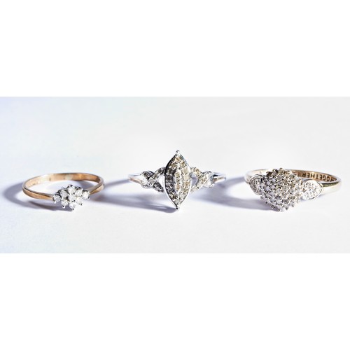 311 - THREE DIAMOND RINGSA silver diamond ring with marquise shaped central section, set with small round ... 