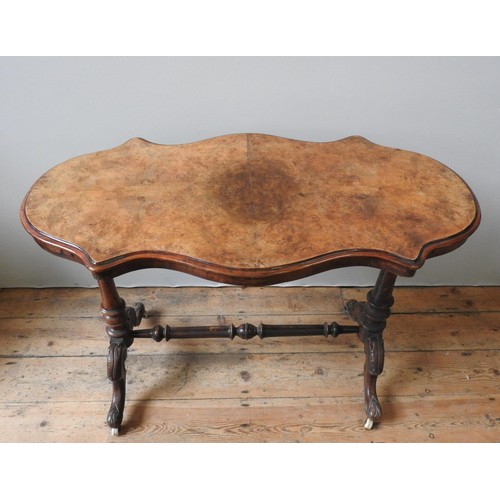 10 - A VICTORIAN WALNUT CENTRE TABLE, with quarter veneered top, two column supports on four outswept fee... 