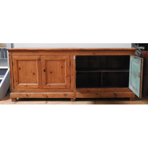 59 - A LARGE 19TH CENTURY CONTINENTAL PINE FOUR DOOR DRESSER BASE, simplistic form with four panelled doo... 