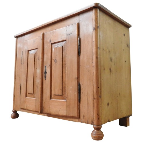 33 - A 19TH CENTURY CONTINENTAL WAXED PINE SIDE CUPBOARD, of simplistic form, with panelled doors enclosi... 