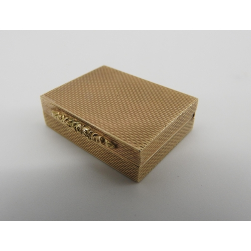 610 - A 9CT GOLD PILL BOX, rectangular form, engine turned exterior with floral decorated clasp, 8 x 25 x ... 