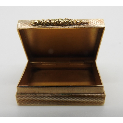 610 - A 9CT GOLD PILL BOX, rectangular form, engine turned exterior with floral decorated clasp, 8 x 25 x ... 