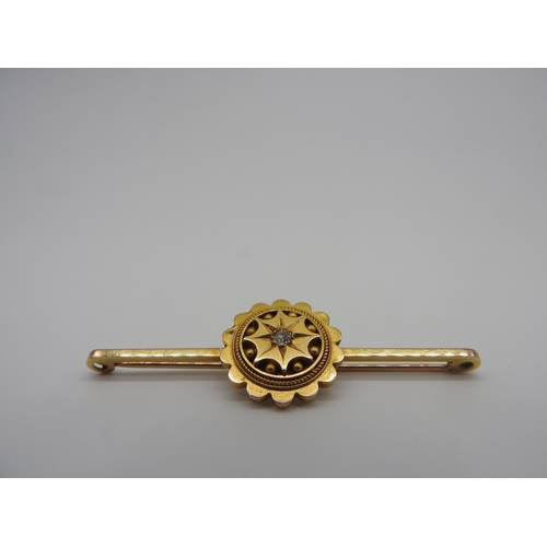 455 - A LATE 19TH CENTURY GOLD ETRUSCAN REVIVAL BROOCH, with a single star set diamond in the centre of a ... 